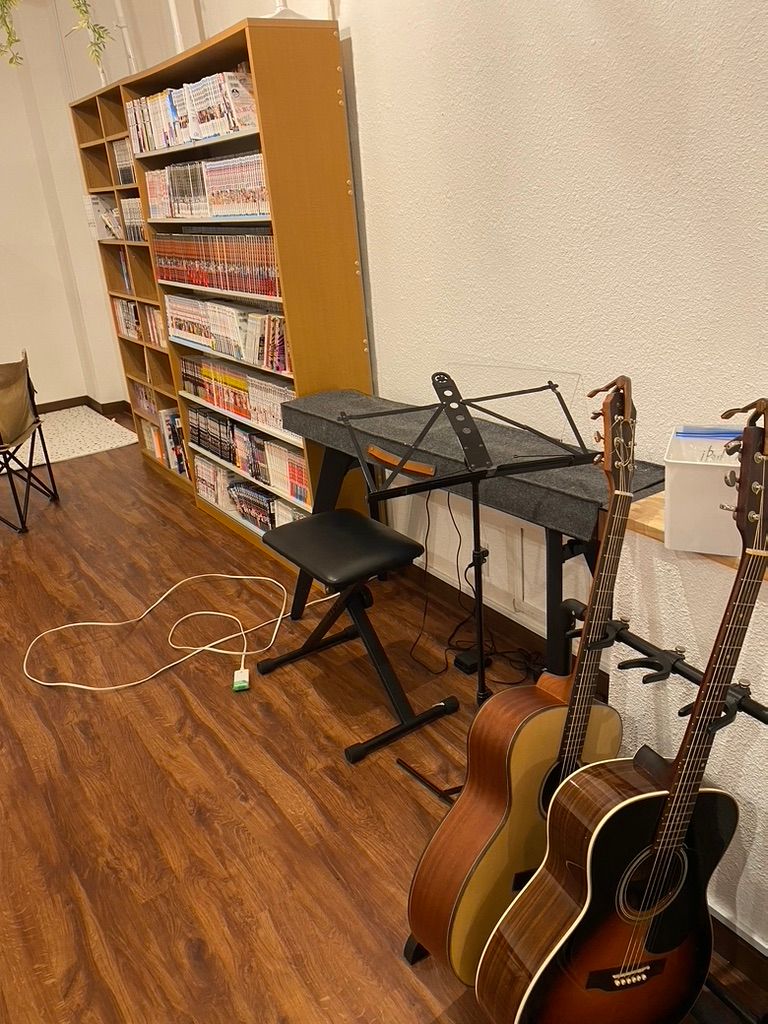 ギターや電子ピアノ、漫画の並ぶ本棚