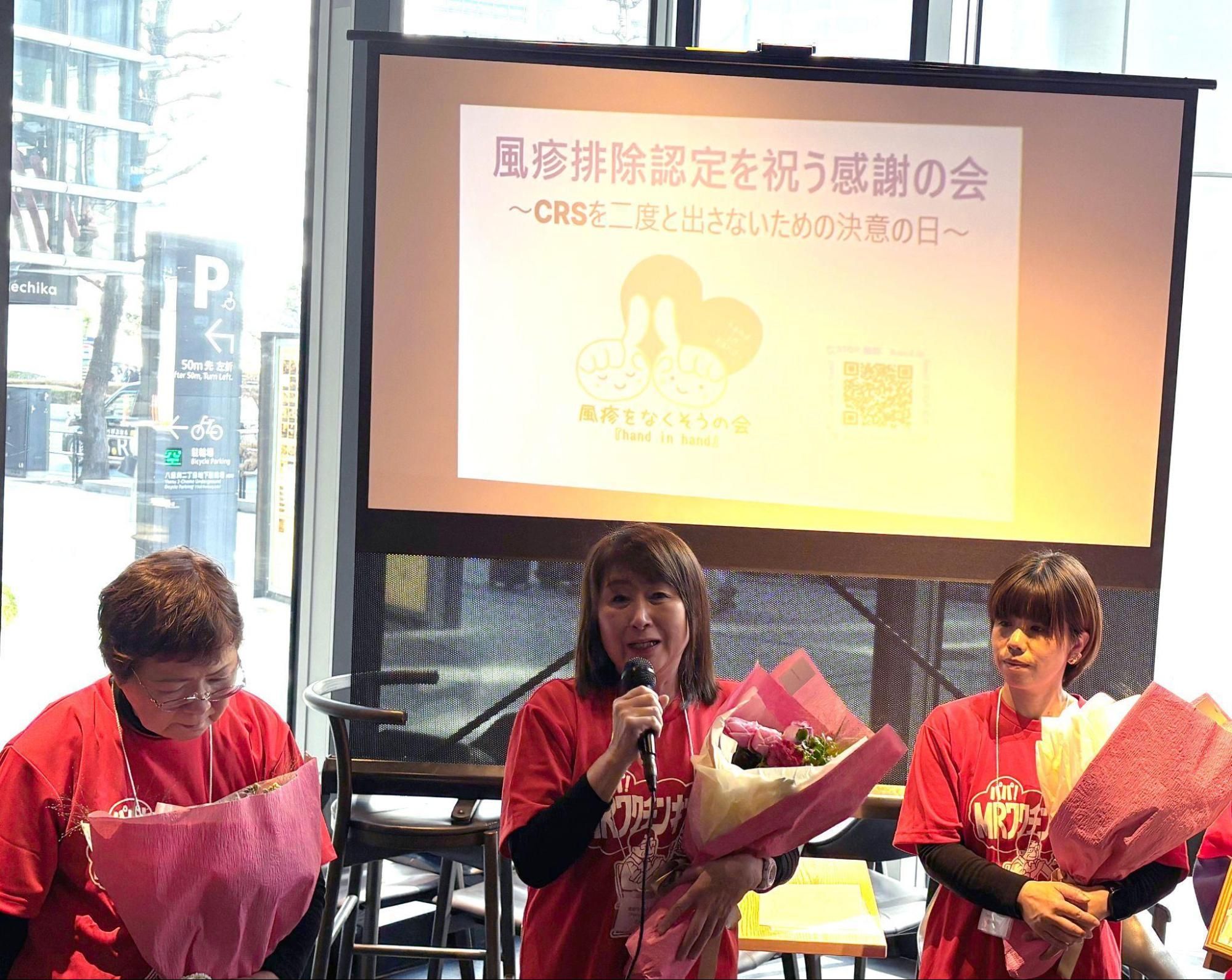 花束を抱えてイベントに登壇する3人の女性