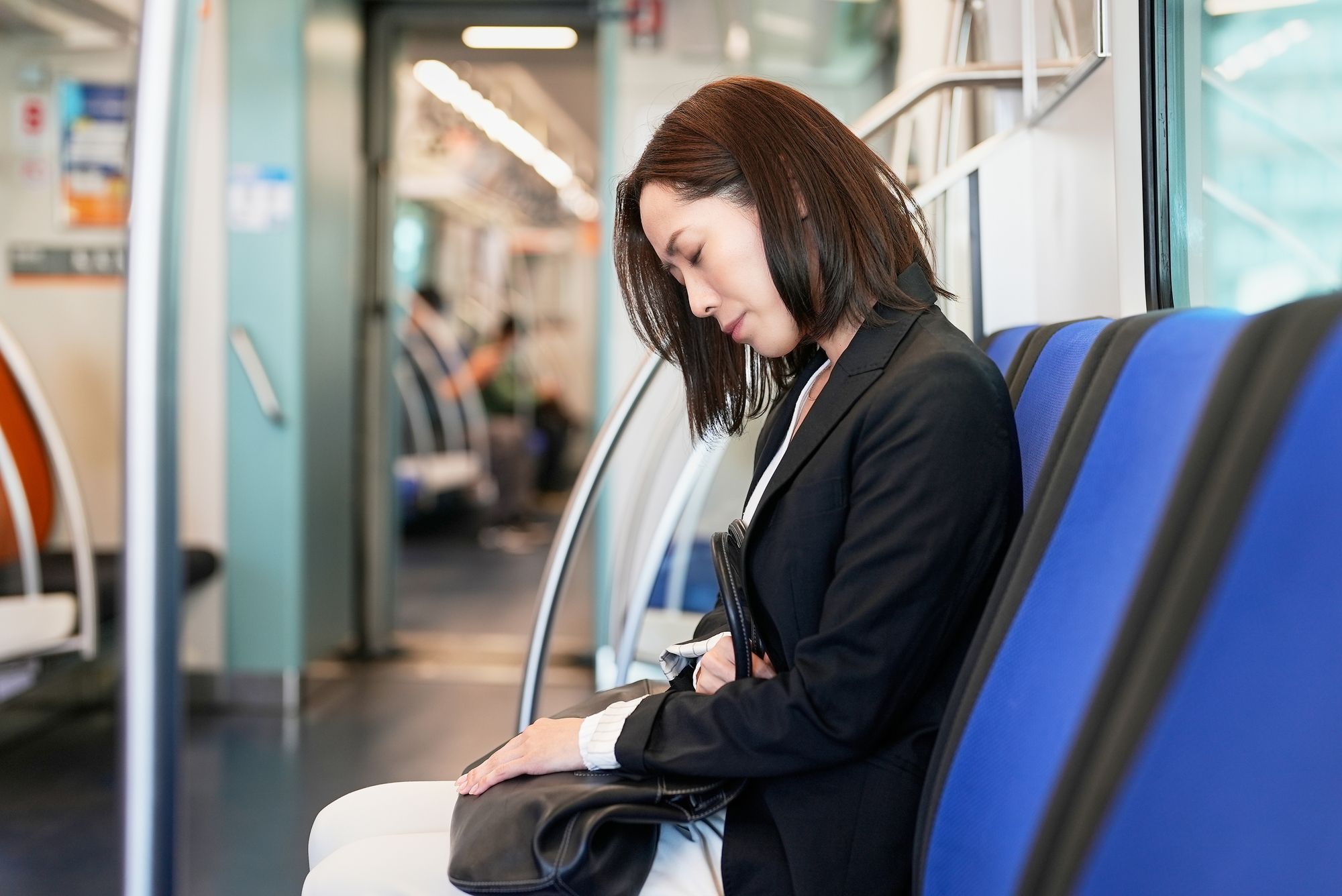 通勤中の電車で腹痛を感じる女性