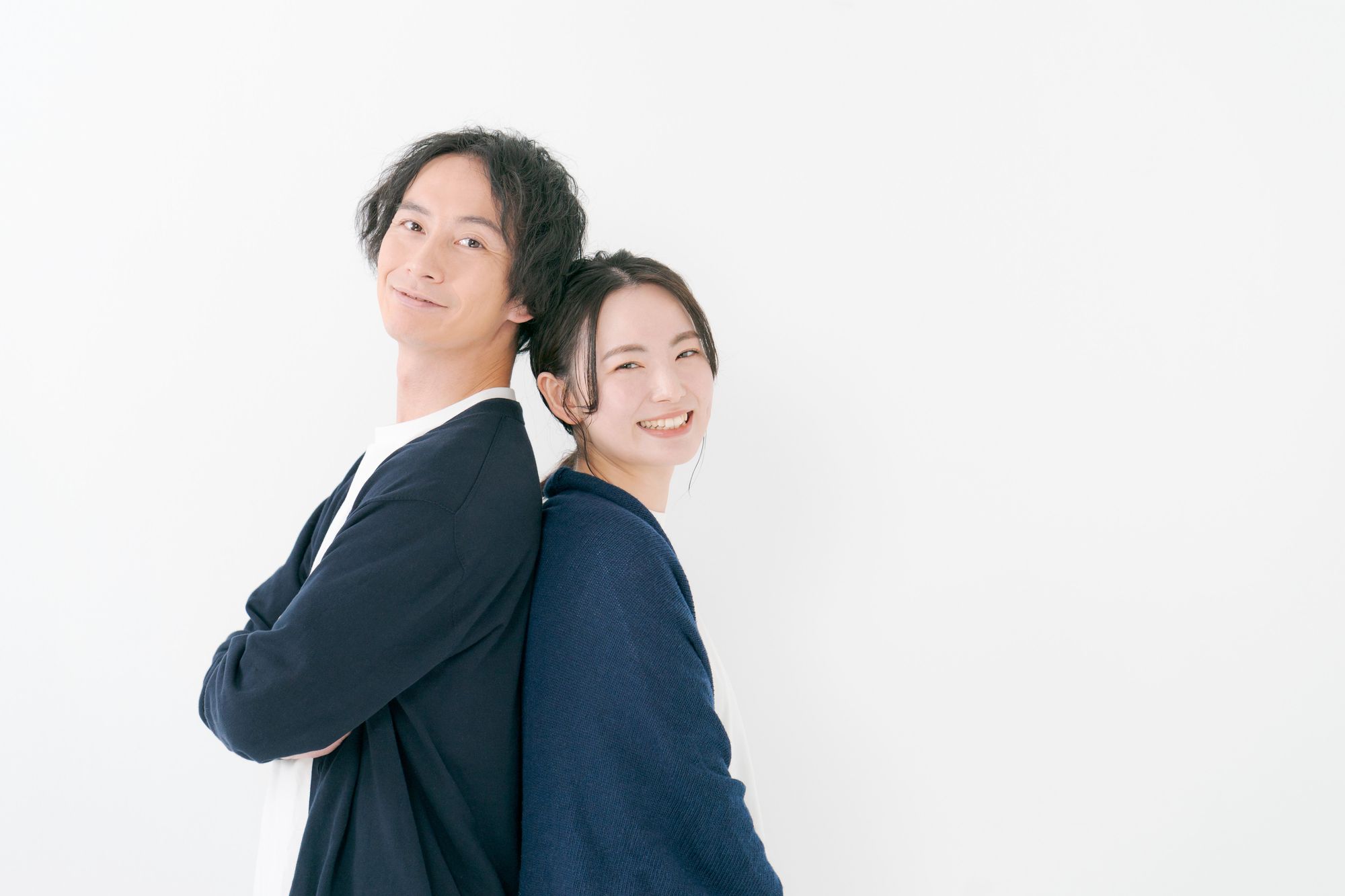 笑顔で背中を合わせる男女