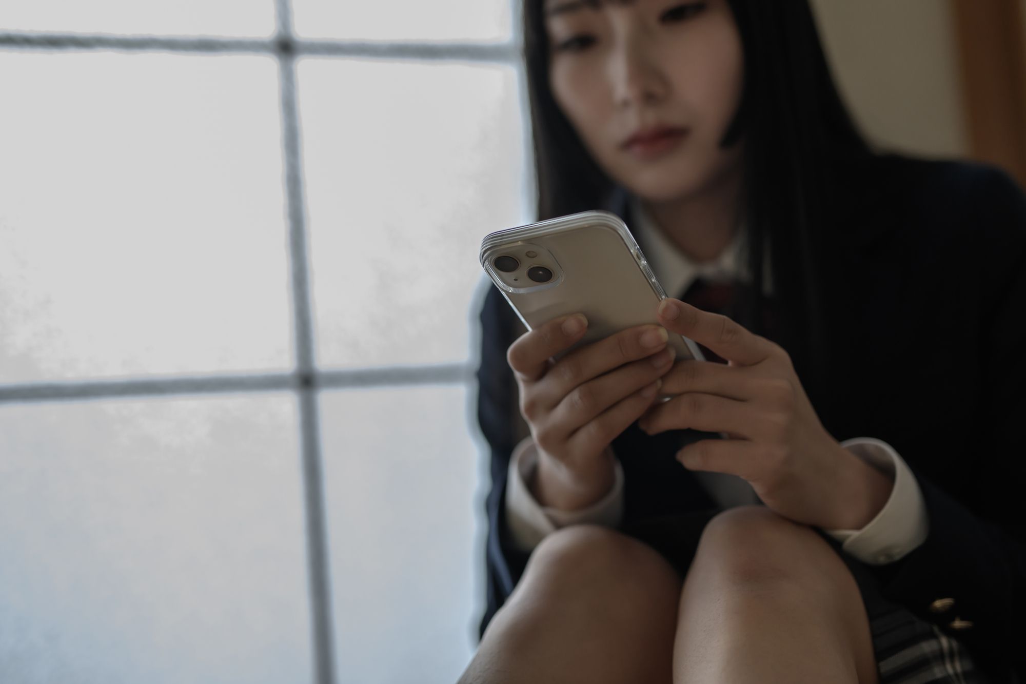 スマートホンを見つめる女子高生