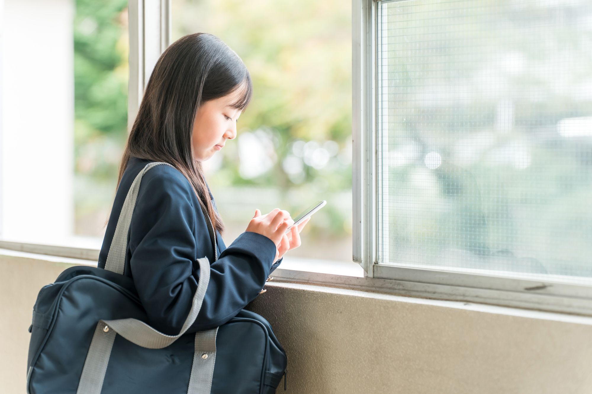 窓際で悩む女子高生