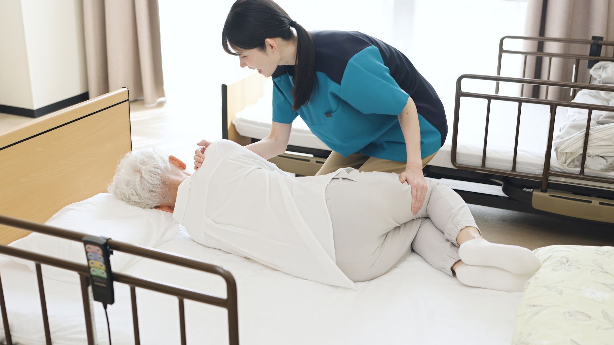 体位変換を行う介護職の女性
