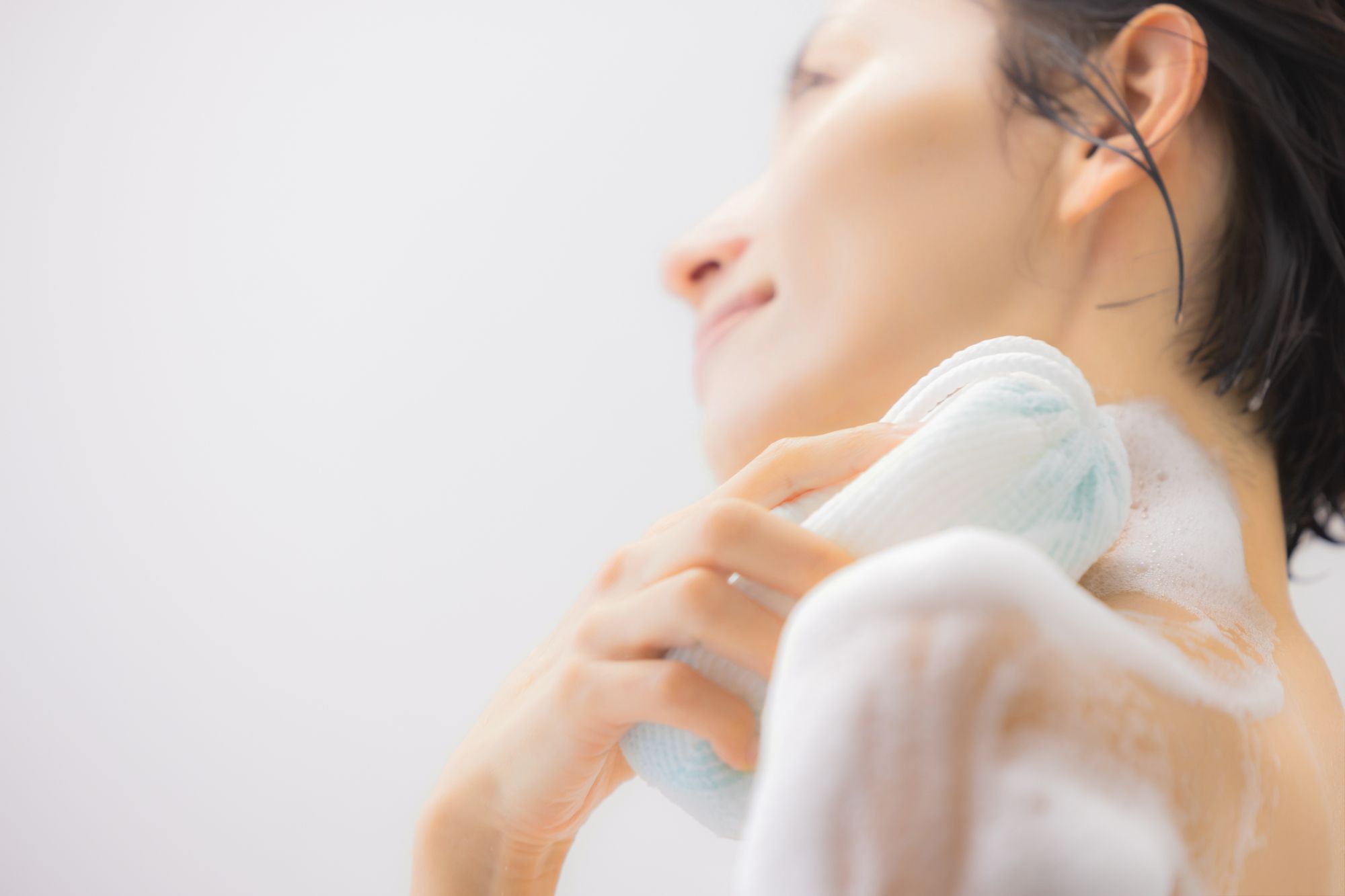 お風呂で体を洗う女性