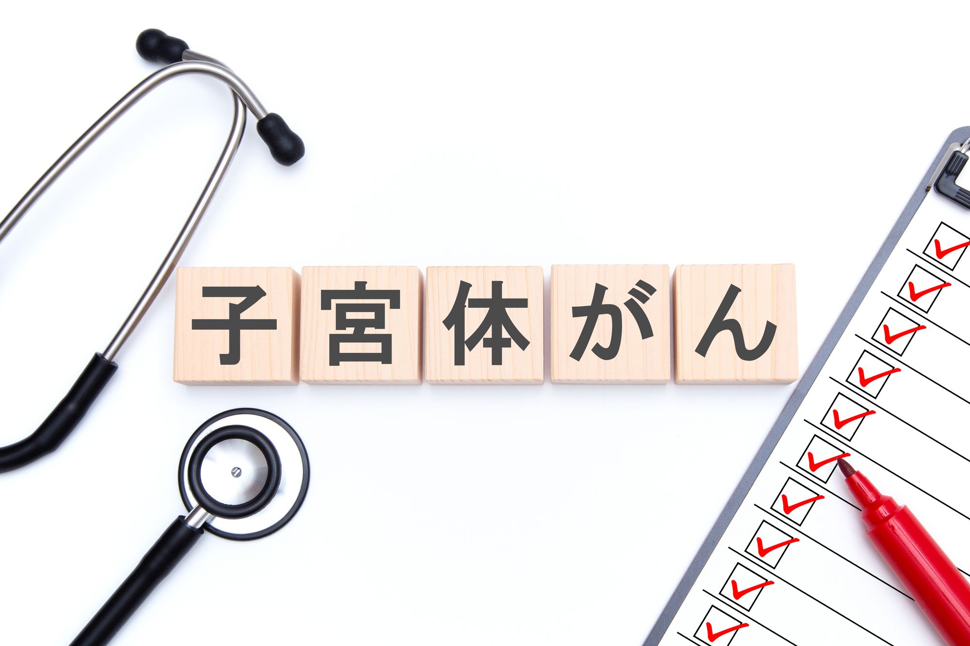 子宮体がんと書かれたプレートと聴診器、問診票