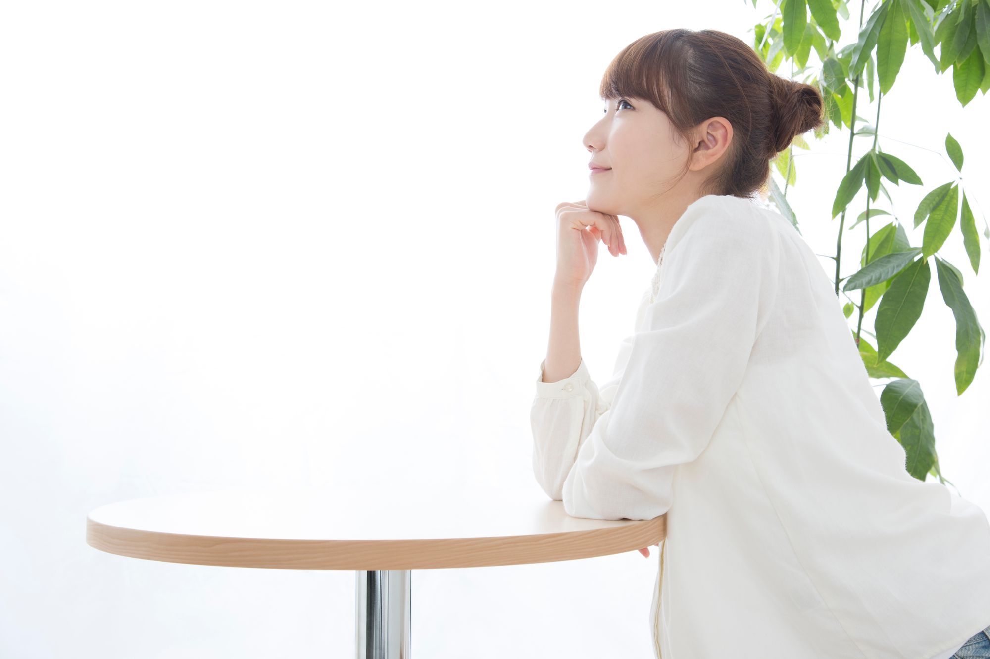 テーブルで将来のことに思いを馳せる女性