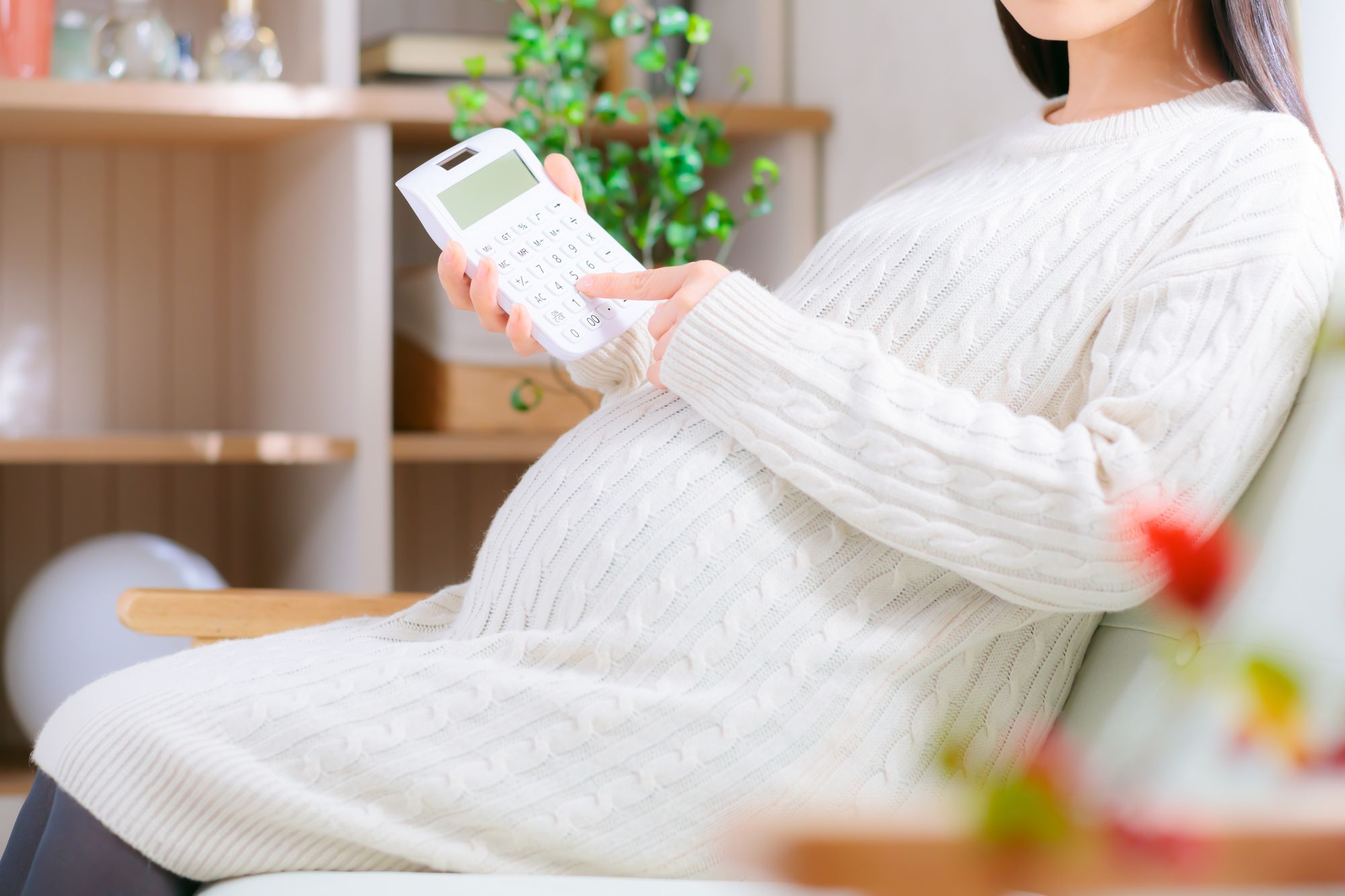 電卓で計算する妊婦