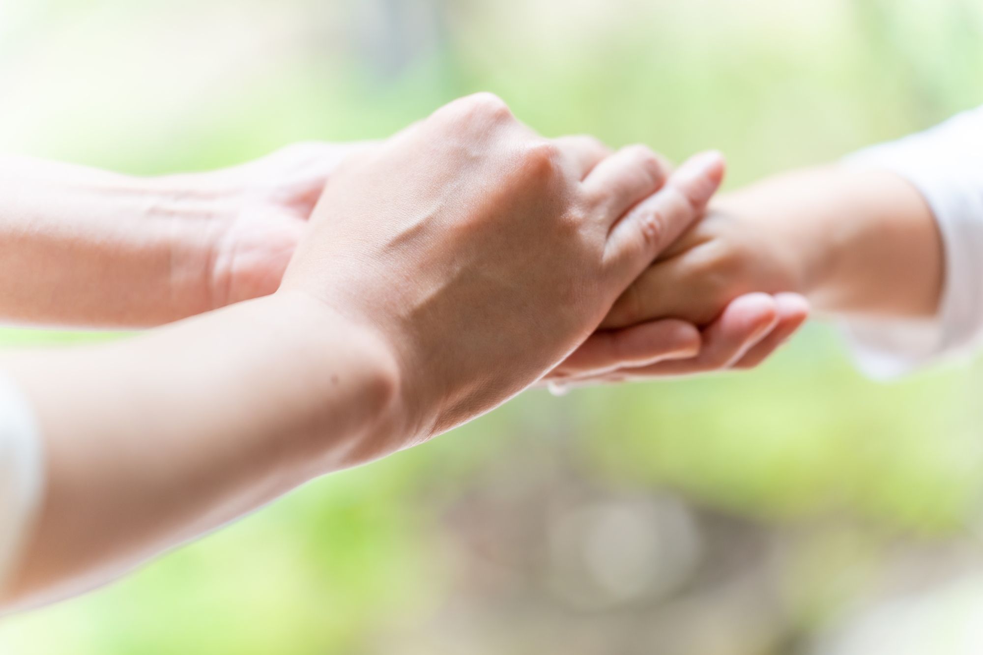 女性の手を握る女性