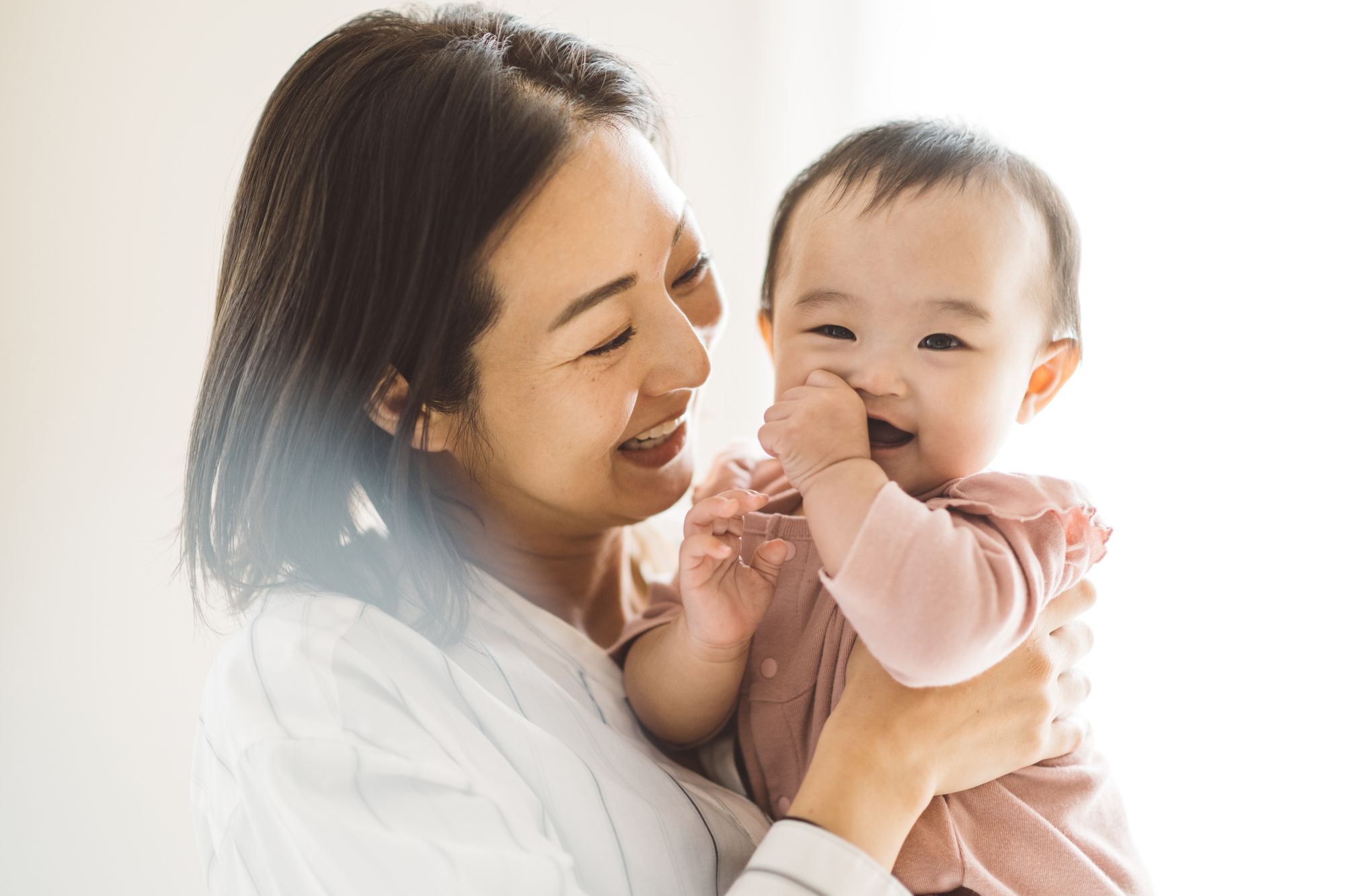 笑顔で赤ちゃんを抱くお母さん